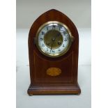An Edwardian string inlaid mahogany cased mantel clock on a stepped plinth and bun feet;