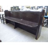 An early 20thC later chocolate brown painted pine pew with a low, level, panelled back,