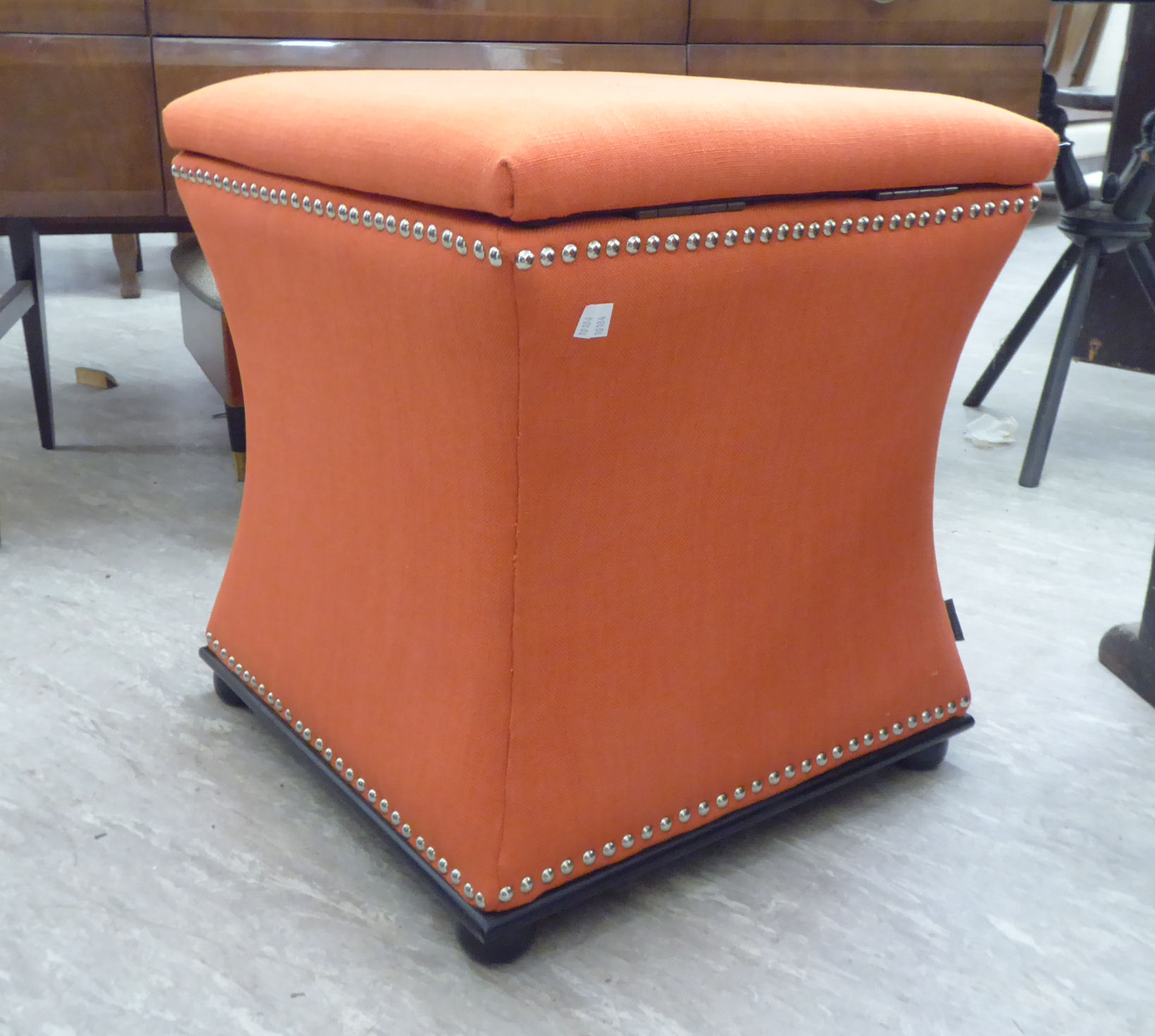 A Regency design box ottoman stool of waisted square form with a hinged top, on button feet,