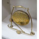 An Art Nouveau inspired brass framed table gong with a striker and a later 6''dia plate 10''h