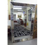 A modern bevelled dressing mirror, set in a conforming, wide,