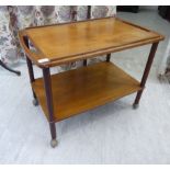 A 1970s teak tray top two tier serving table with cut-out ends,