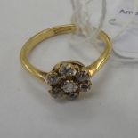 An 18ct gold and platinum ring fashioned as a daisy and set with seven diamonds 11