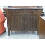 An early 20thC stained oak sideboard with an arched, pierced upstand,