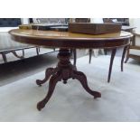 A late Victorian mahogany breakfast table, the oval tip-top on a baluster column,