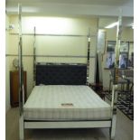 A modern bed frame with bevelled mirror clad uprights and rails,