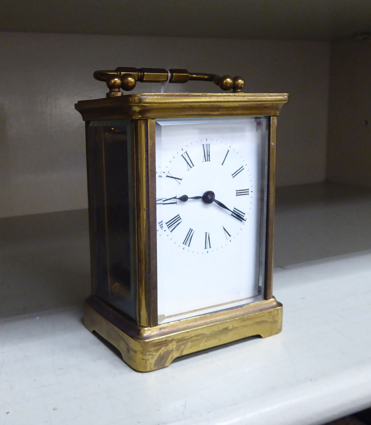 An early/mid 20thC brass cased carriage timepiece with bevelled glass panels and a folding top