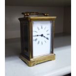An early/mid 20thC brass cased carriage timepiece with bevelled glass panels and a folding top