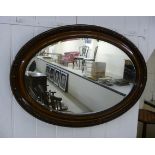 A 1920s bevelled oval mirror,