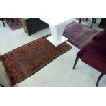 A Persian rug on a rust coloured ground 45'' x 43'';
