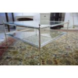 A modern polished steel framed coffee table with a bevelled clear glass top and undertier,