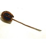 A yellow metal stickpin with a pearl and tiger's eye set horseshoe terminal 11