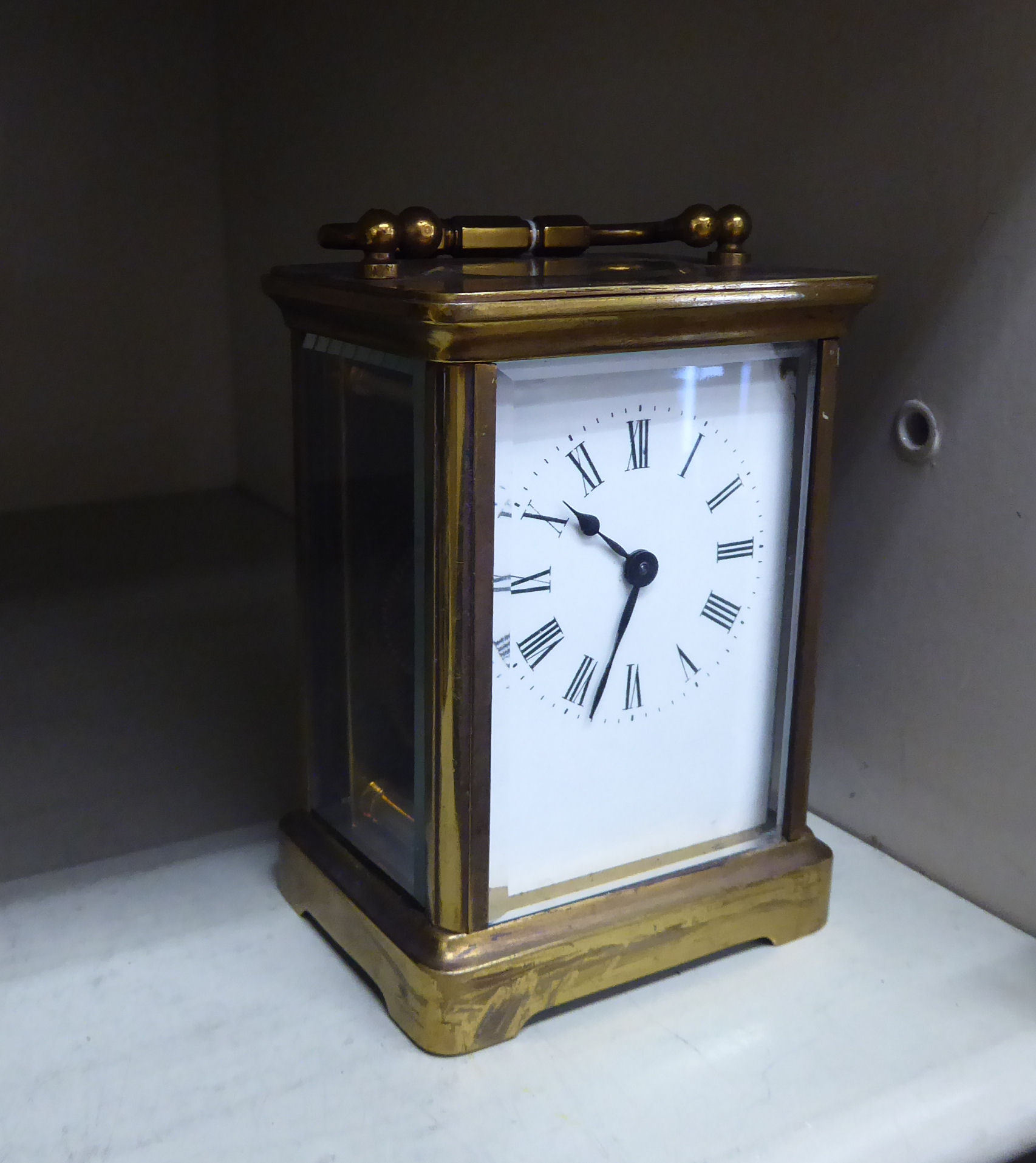 An early/mid 20thC brass cased carriage timepiece with bevelled glass panels and a folding top