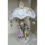 A 20thC Continental porcelain novelty table lamp, fashioned as 19thC children,