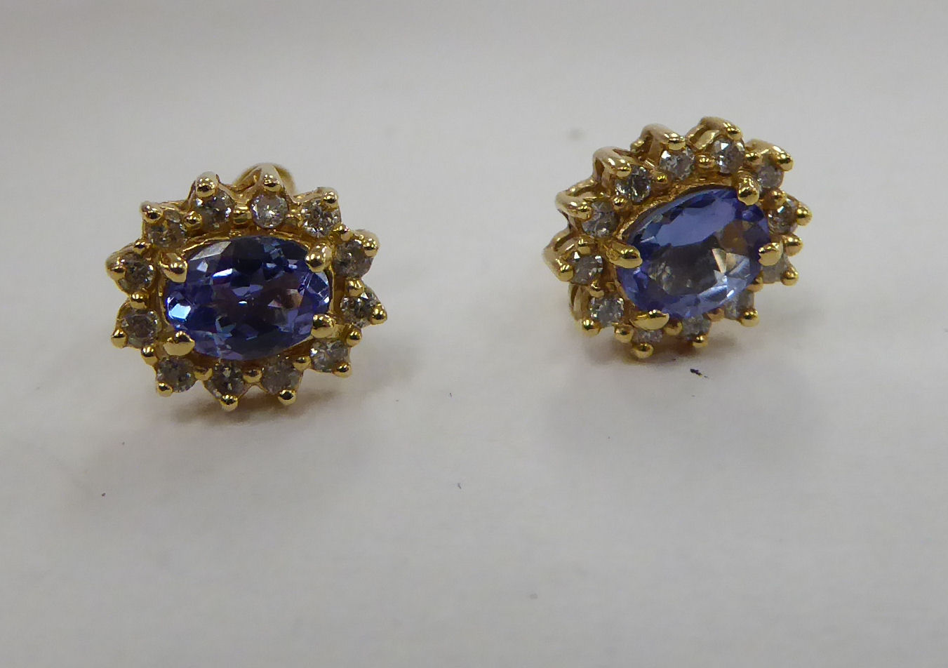 A pair of 14ct gold claw set tanzanite and diamond set earrings 11