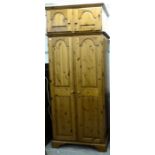 A modern Ducal honey coloured pine wardrobe, enclosed by a pair of twin panelled, full-height doors,