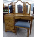 A modern Ducal honey coloured pine dressing table, raised on an offset,