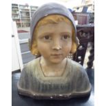 A 1920s painted plaster bust, a girl wearing a cap bears various indistinct impressions 13.