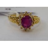 An 18ct gold claw set ruby and diamond cluster ring 11