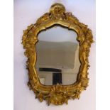 A mid 19thC mirror, set in a decoratively carved giltwood and gesso frame,