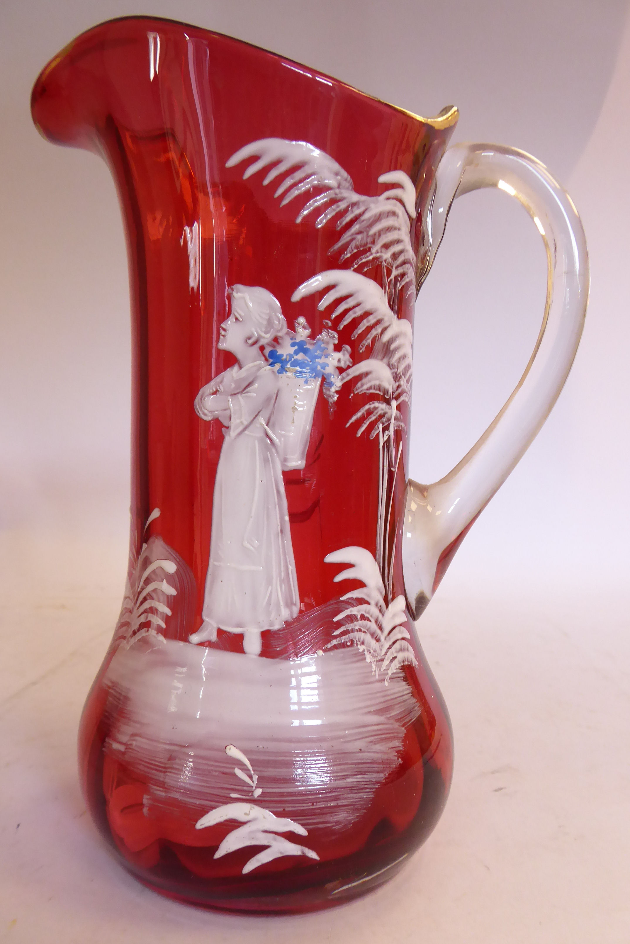 In the manner of Mary Gregory - a cranberry glass jug of waisted bulbous form,