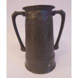 An Art Nouveau pewter vase of tapered cylindrical form with opposing loop handles,