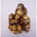A late 19thC stained and carved ivory netsuke, set with pin-head size coloured stone beads,