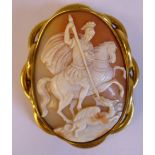 An oval shell carved cameo brooch, featuring St George slaying the dragon, in a yellow metal,