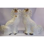 A pair of Staffordshire pottery ivory glazed, seated King Charles Spaniels with painted features,