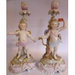 A pair of early 20thC German floral encrusted, painted porcelain candlesticks,