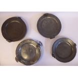 Four similar 18thC and 19thC pewter broad rimmed plates with opposing ring handles,