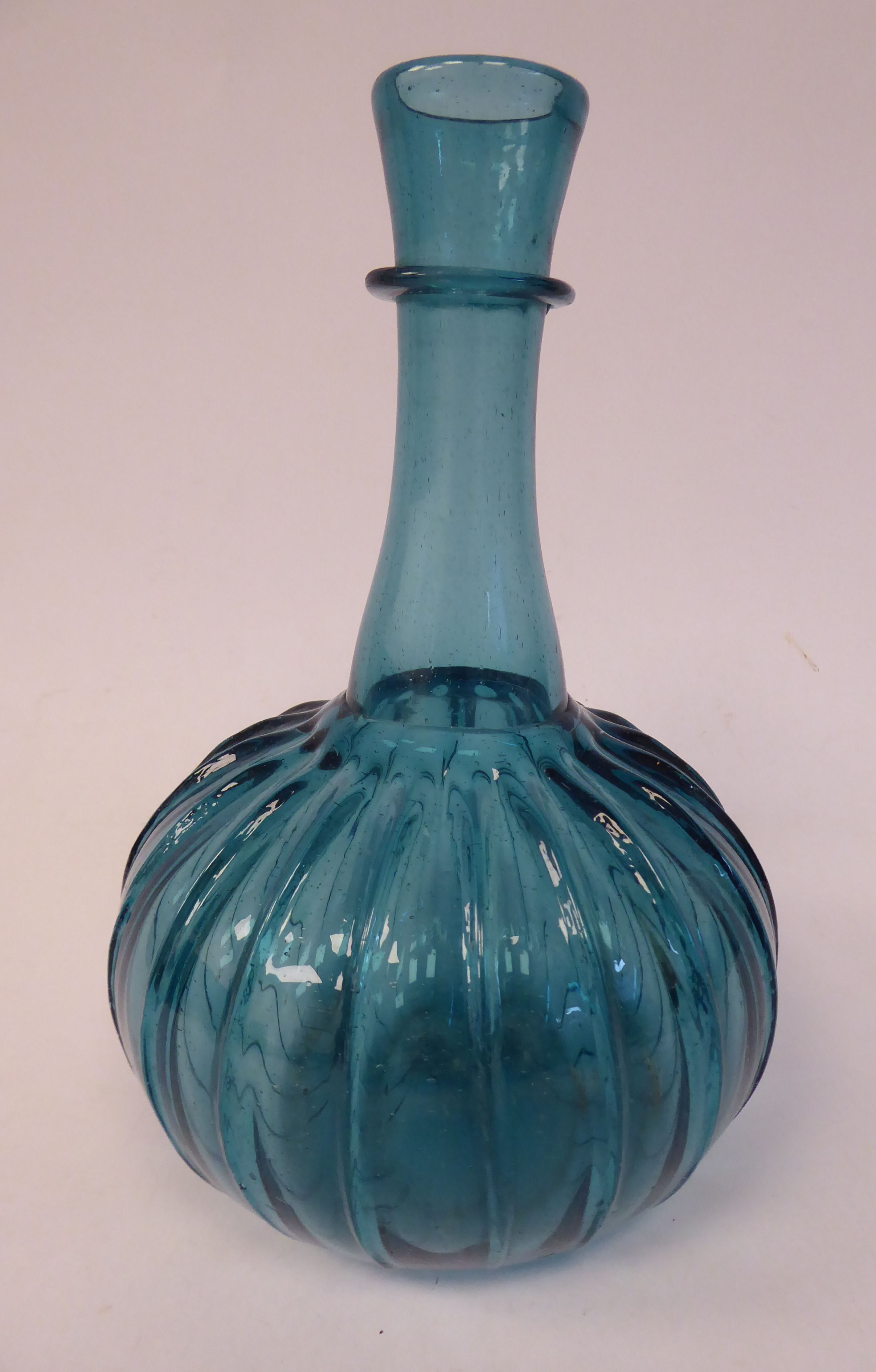 A 17thC Dutch semi-opaque turquoise glass bulbous and wide fluted bottle vase with a long,