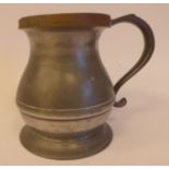A mid 19thC pewter quart size measure of banded baluster form with an S-scrolled handle and an