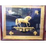 An early 19thC cast lacquered brass plaque, a performing horse, on a scrolled plinth,