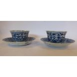 A pair of early 18thC Chinese porcelain tea bowls and saucers, having serpentine outlined borders,