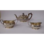 A three piece silver tea set of oval ogee form with gadrooned rims, comprising a teapot,