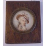 An early 20thC circular head and shoulders portrait miniature, a fashionable young woman 1.