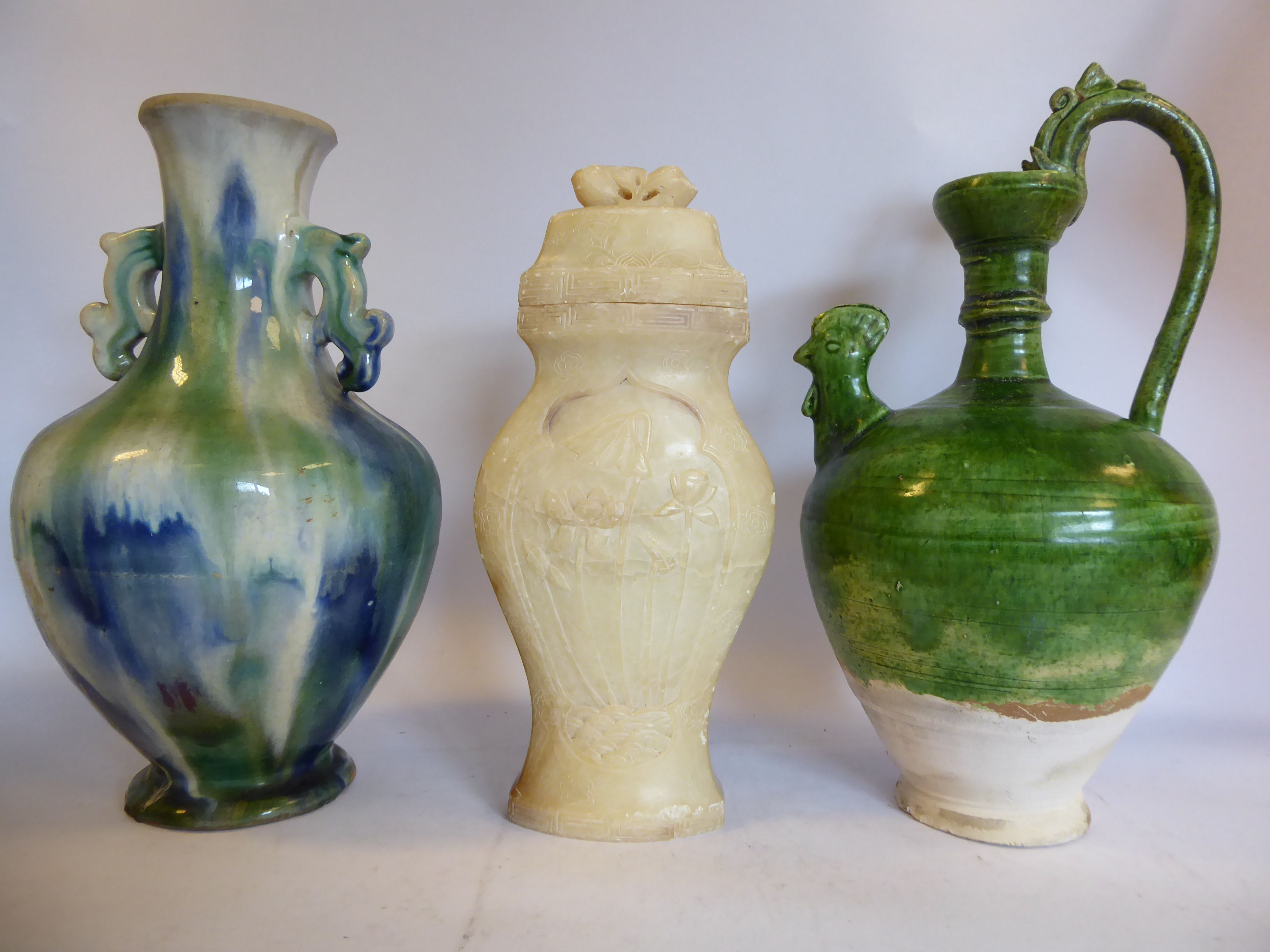 An 'antique' Chinese green glazed pottery ewer of tapered and shouldered baluster form with a high