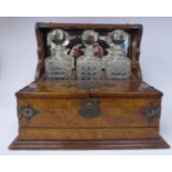 A 1920s honey coloured oak and rivetted brass mounted combination tantalus and games compendium box,
