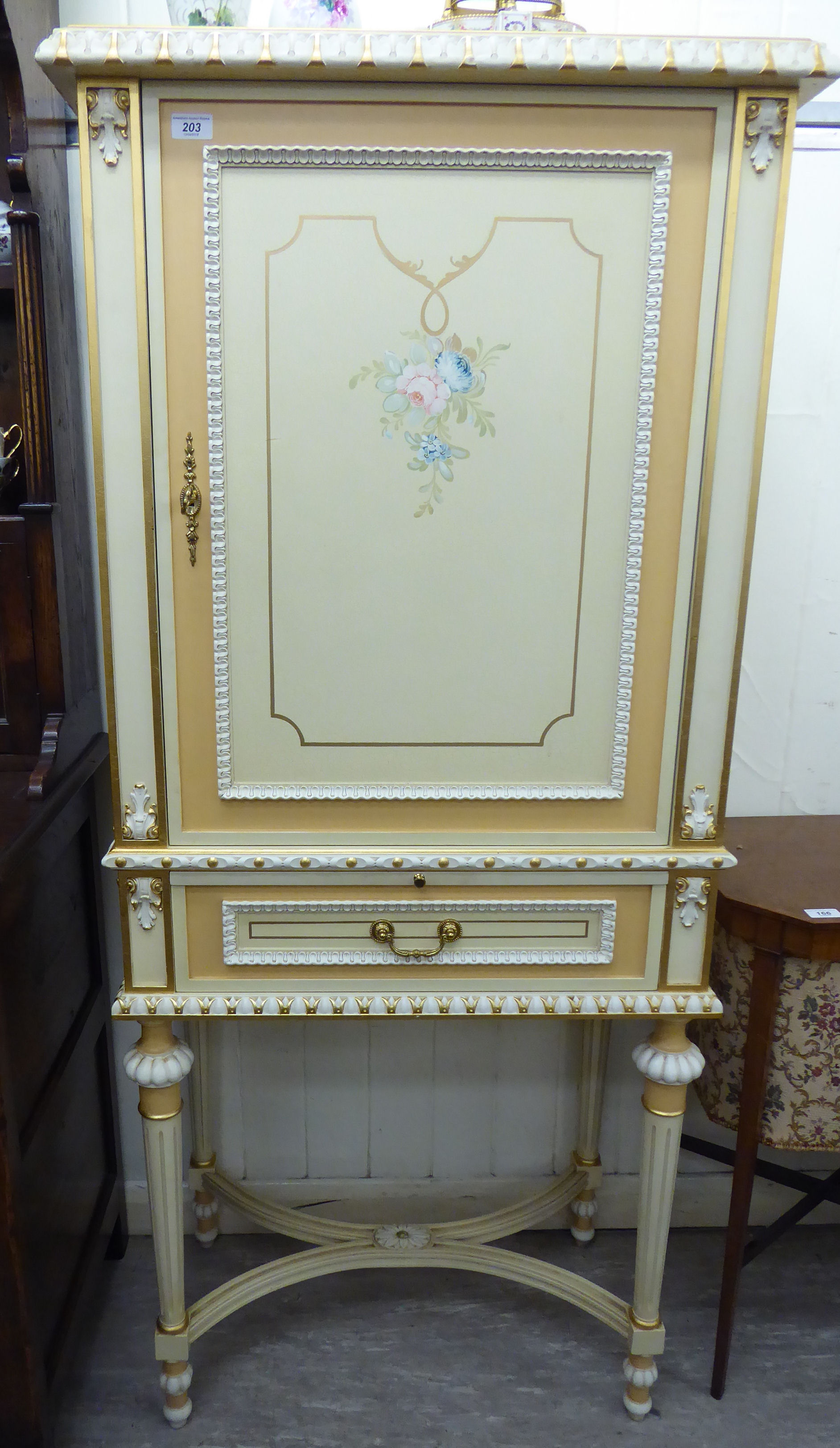A modern Continental carved, gilded and painted cocktail cabinet with stiff leaf and other ornament,