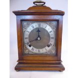 A 20thC Georgian style mahogany cased bracket clock with a folding brass handle on the domed top,