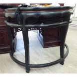 A 20thC Chinese black and iron red lacquered elm D-shaped console table with a wavy edged apron,