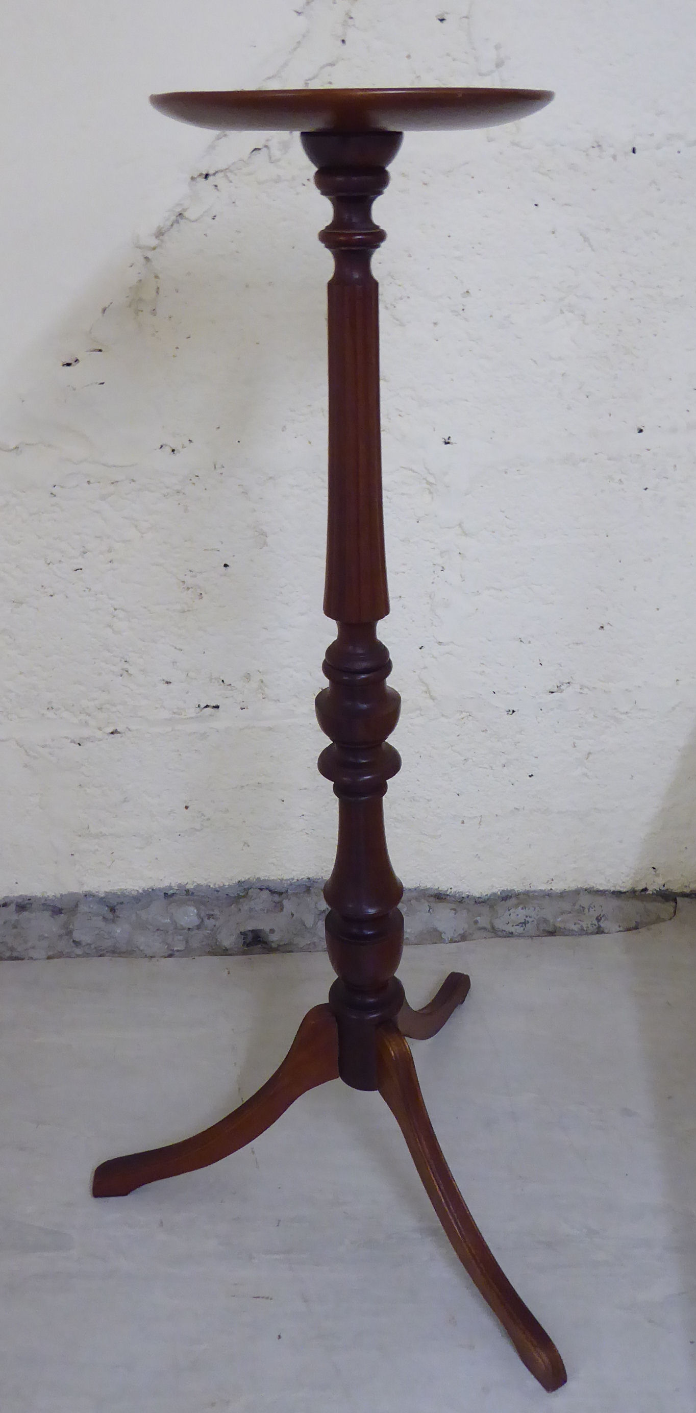 A Victorian style mahogany torchere, the turned top over a demi-reed carved column,