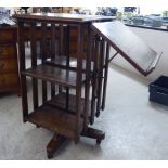 An Edwardian oak revolving bookcase, comprising two tiers with slatted sides,