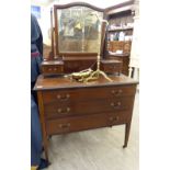 An Edwardian string inlaid mahogany dressing table, surmounted by a pivoting bevelled mirror,