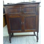 A 1920s carved bead bordered oak side cabinet, enclosed by two pairs of panelled doors,