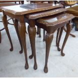 A modern nesting set of three walnut occasional tables with serpentine outlined tops,