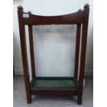 A 1920s oak stickstand with a divided superstructure, on square supports,