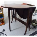 An Edwardian mahogany Sutherland style occasional table with an oval top, raised on waisted,