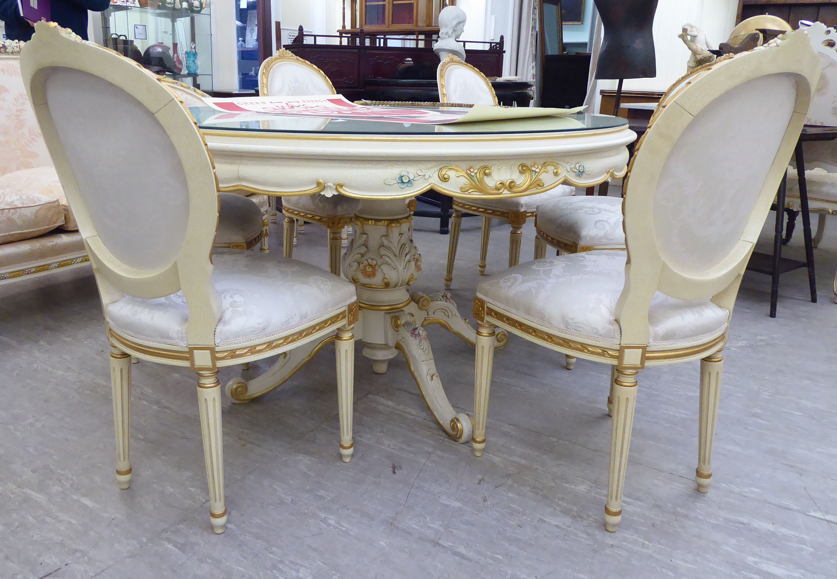 A modern Continental carved, gilded and painted dining table with a plate glass top,